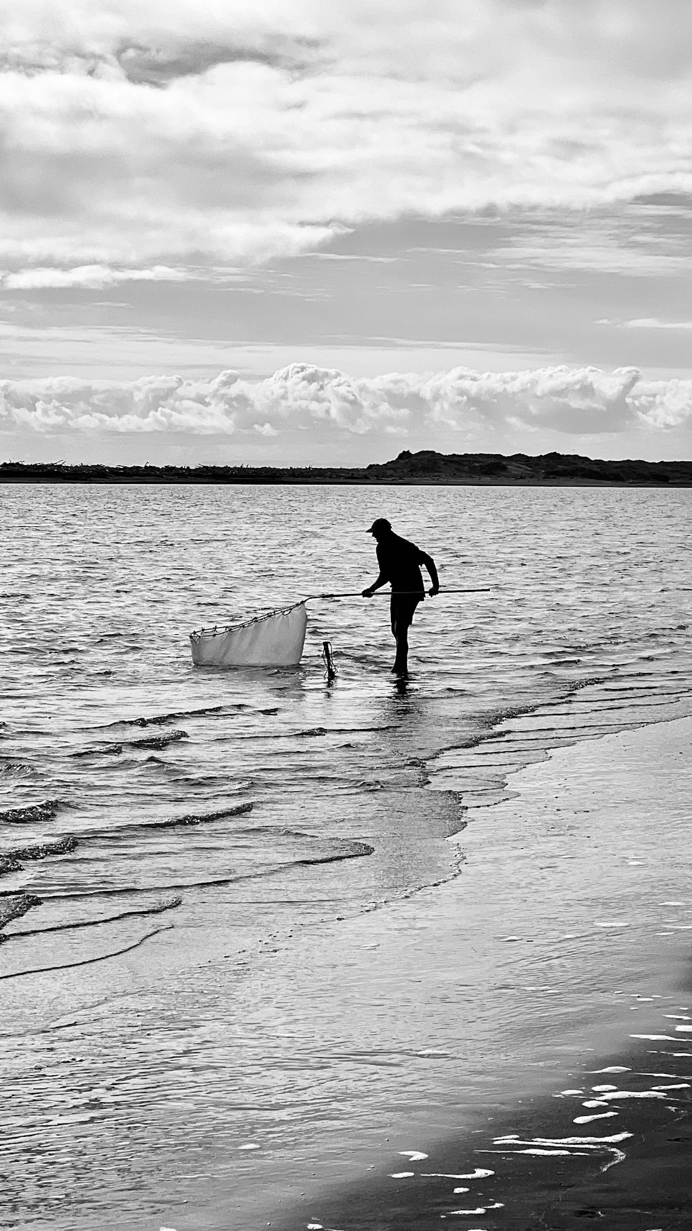 a man standing in the water with a boat