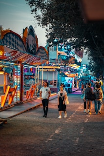 people walking on a street with a colorful building in the background