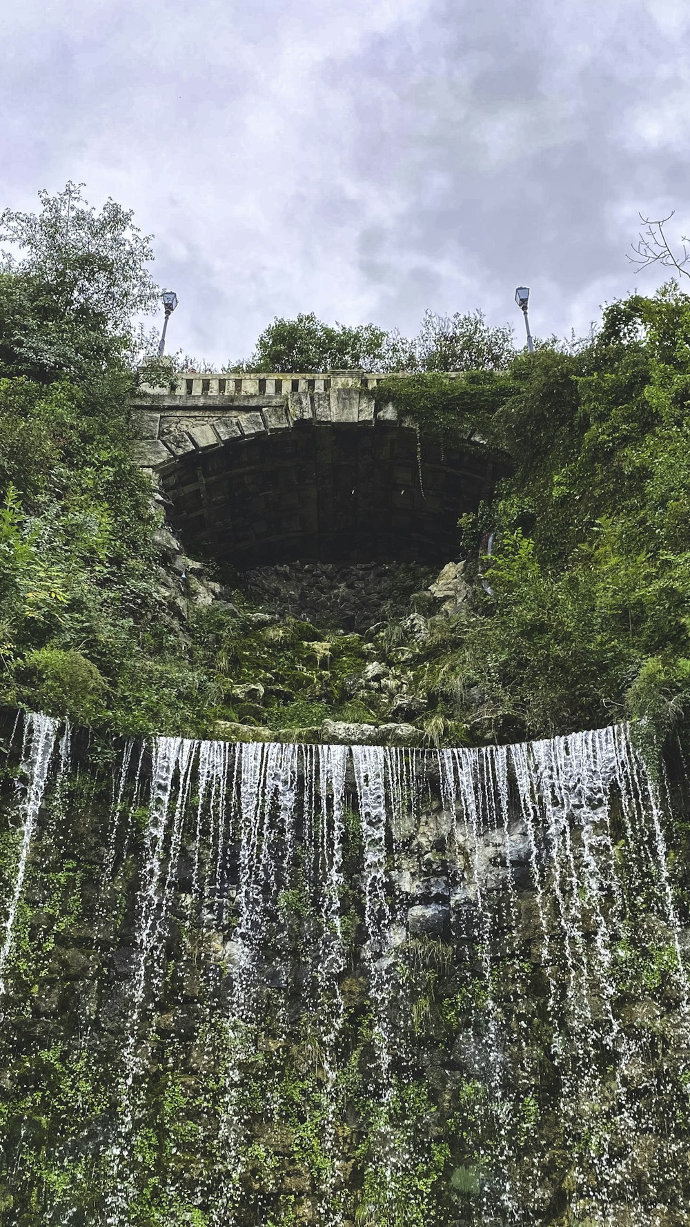 a waterfall with a bridge over it