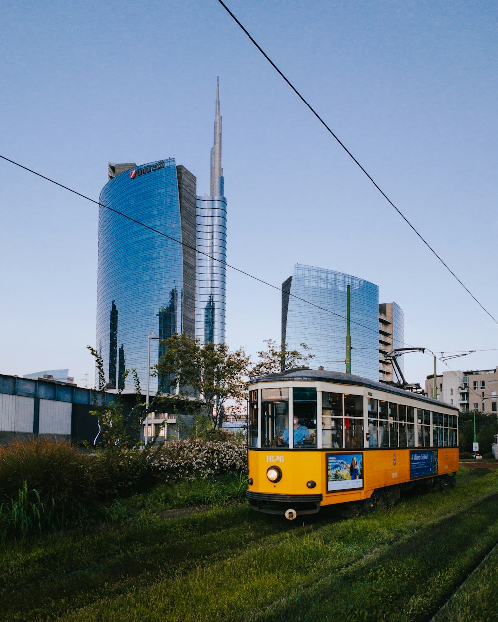a trolley on a road with tall buildings in the background