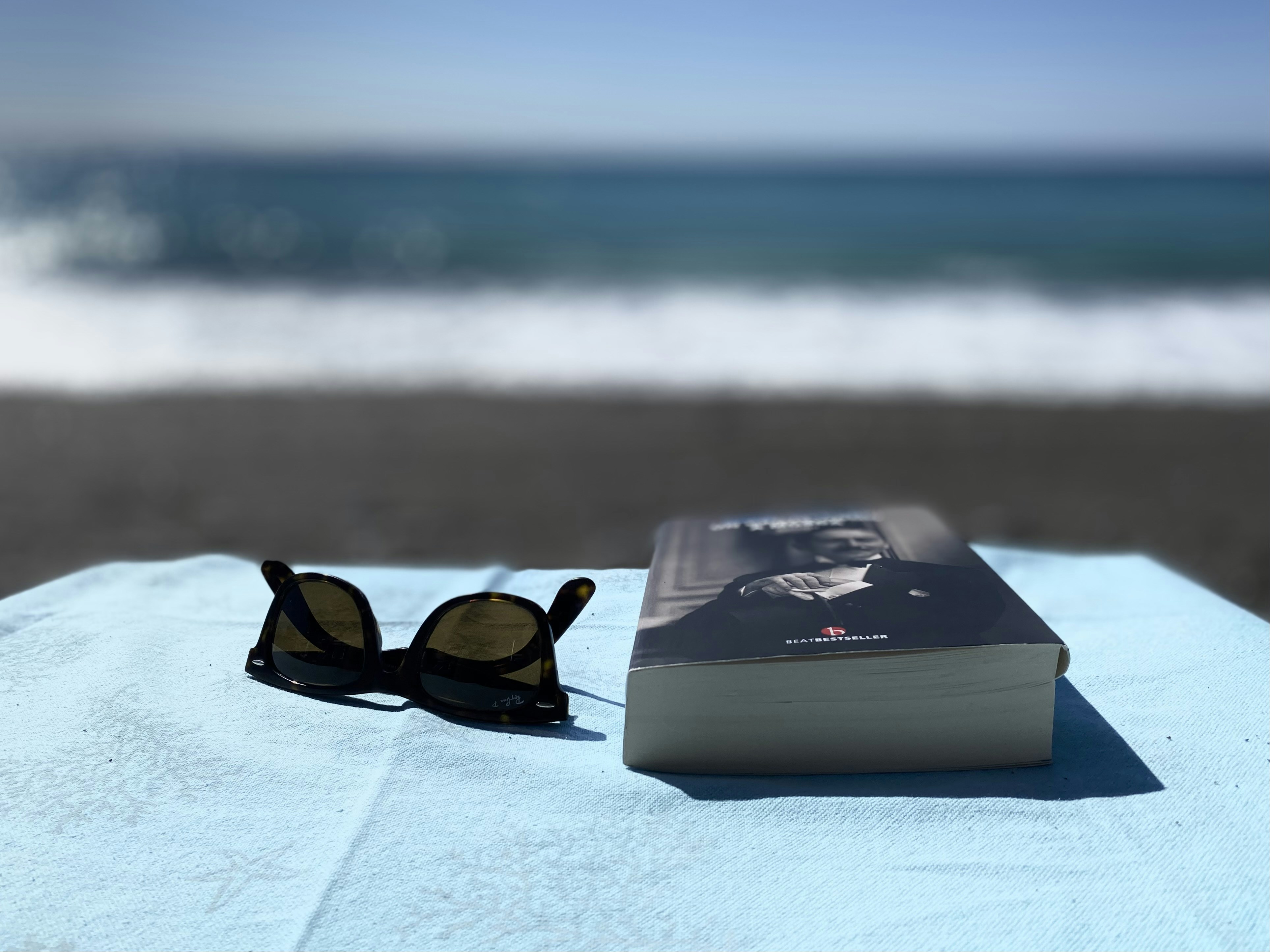 a pair of sunglasses and a wallet on a beach