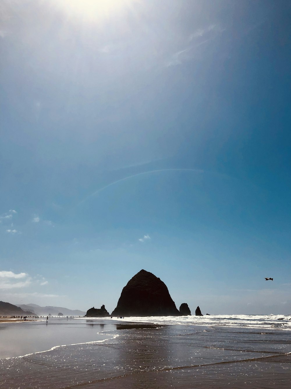 a beach with a rock formation in the distance