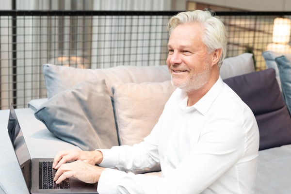 a man sitting on a couch using a laptop