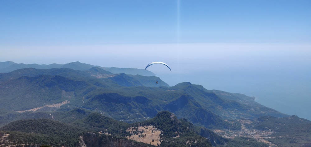 a person parachuting over a valley