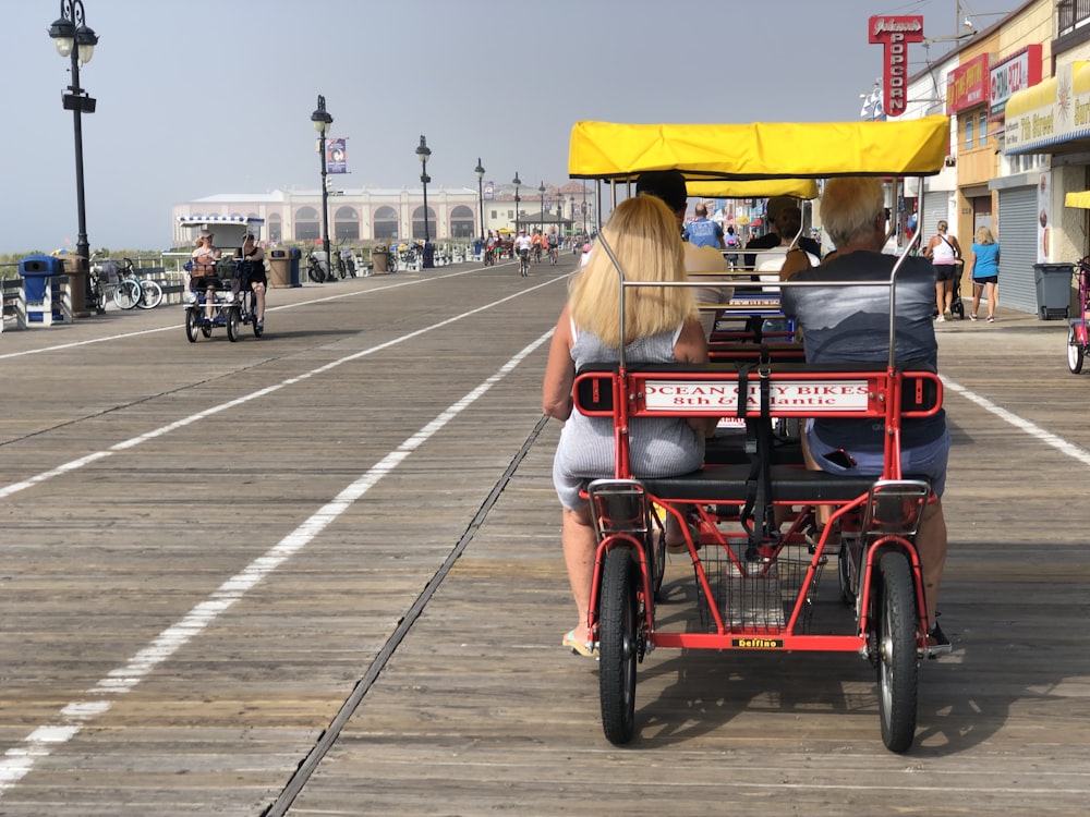 a couple of people riding a small cart with a canopy on a street