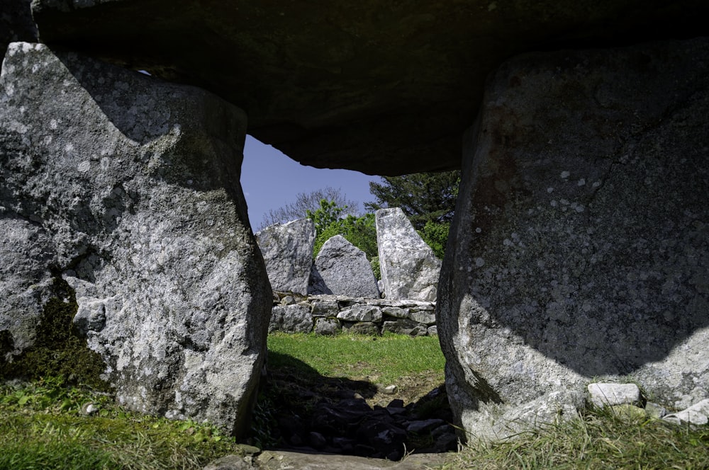 a stone archway with grass and rocks