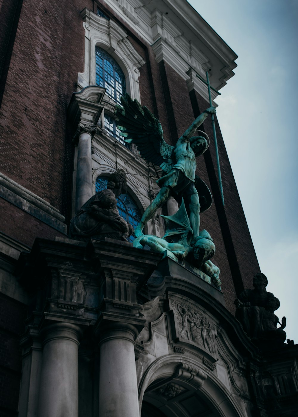 a statue of a person holding a staff in front of a building