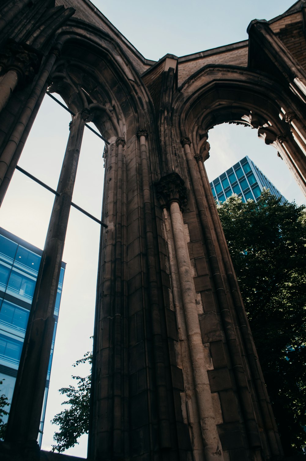 a stone archway with a pole and trees in the background