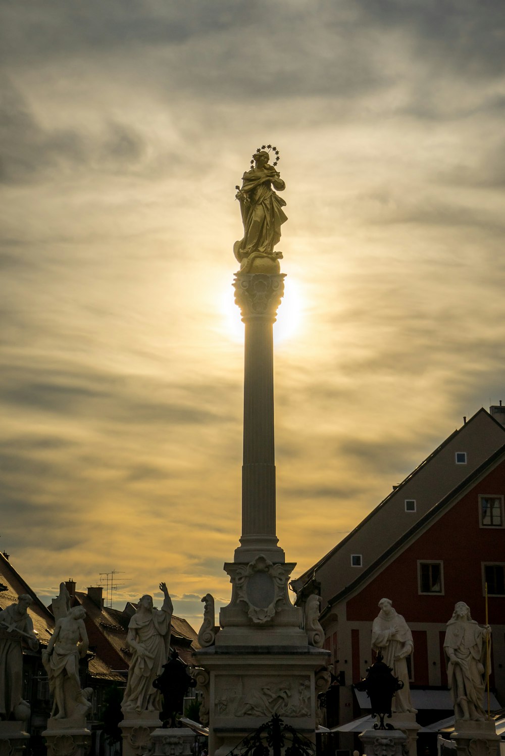 a tall statue with a group of people around it