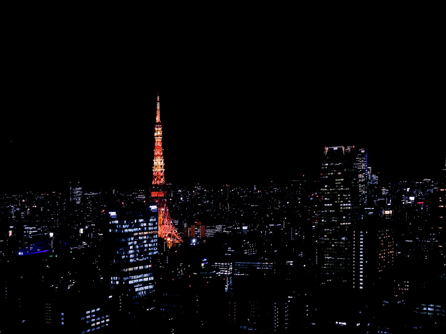 Illuminated Tokyo Tower rising above Tokyo skyline at night