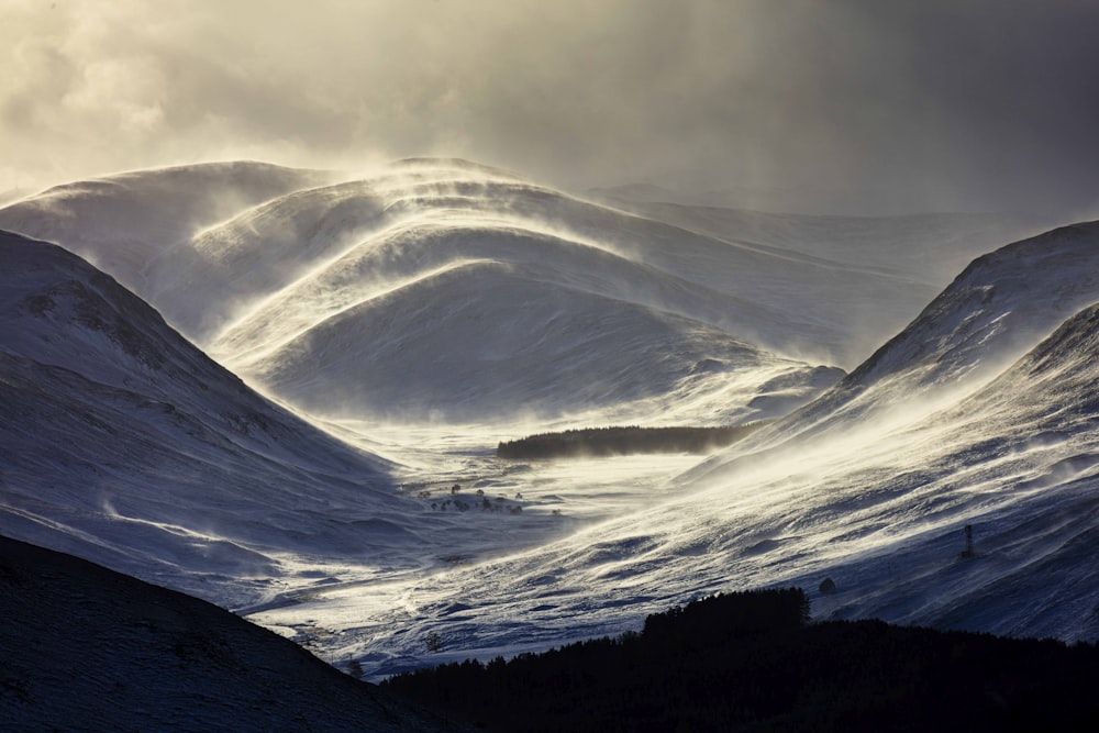 a snowy mountain with a valley below