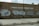A brick wall of a community school is covered with large, stylized graffiti featuring bubble letters in black and silver. The school name, T. Wendell Williams Community School, is displayed in white block letters above the graffiti. The graffiti includes various tags and symbols.