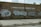 A brick wall of a community school is covered with large, stylized graffiti featuring bubble letters in black and silver. The school name, T. Wendell Williams Community School, is displayed in white block letters above the graffiti. The graffiti includes various tags and symbols.