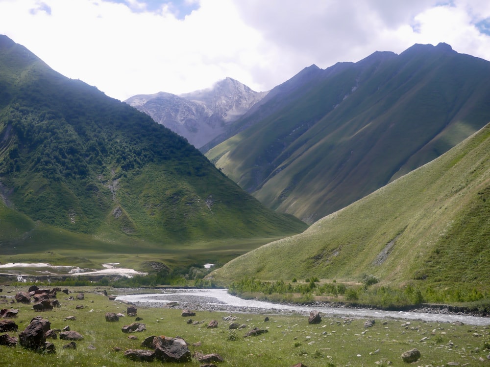 a river running through a valley between mountains