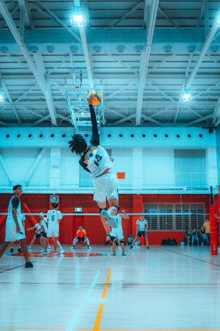 Close-up of a volleyball mid-air as a young athlete prepares to spike it.