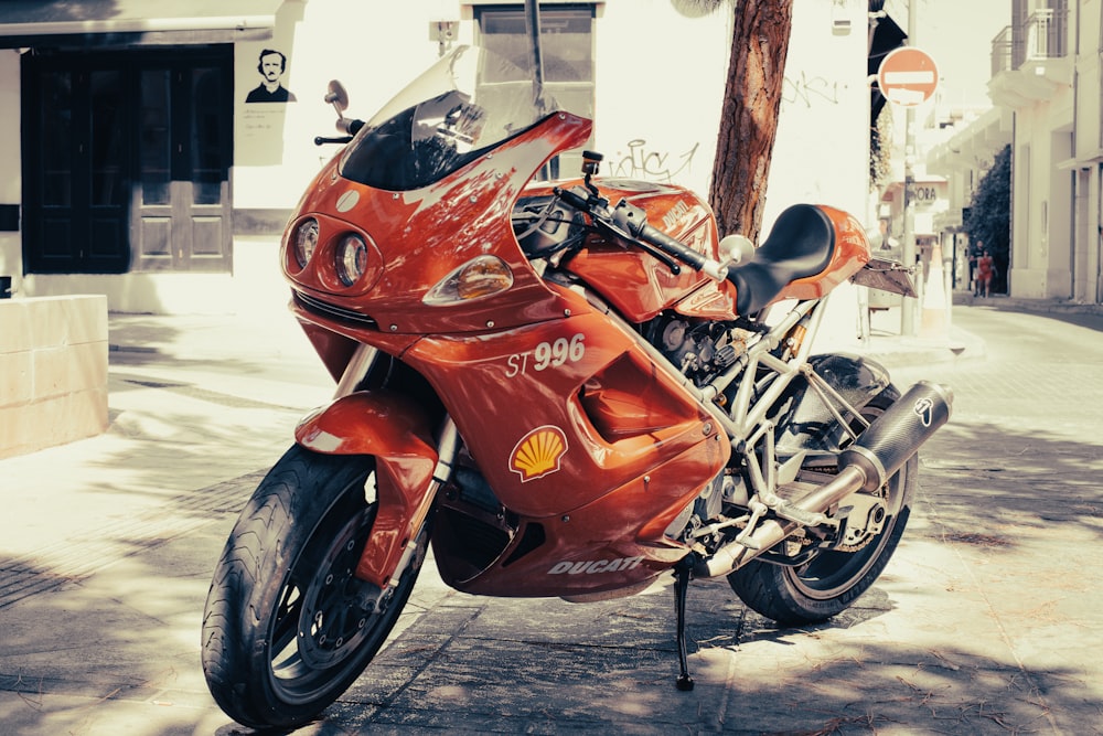 a red motorcycle parked on the sidewalk