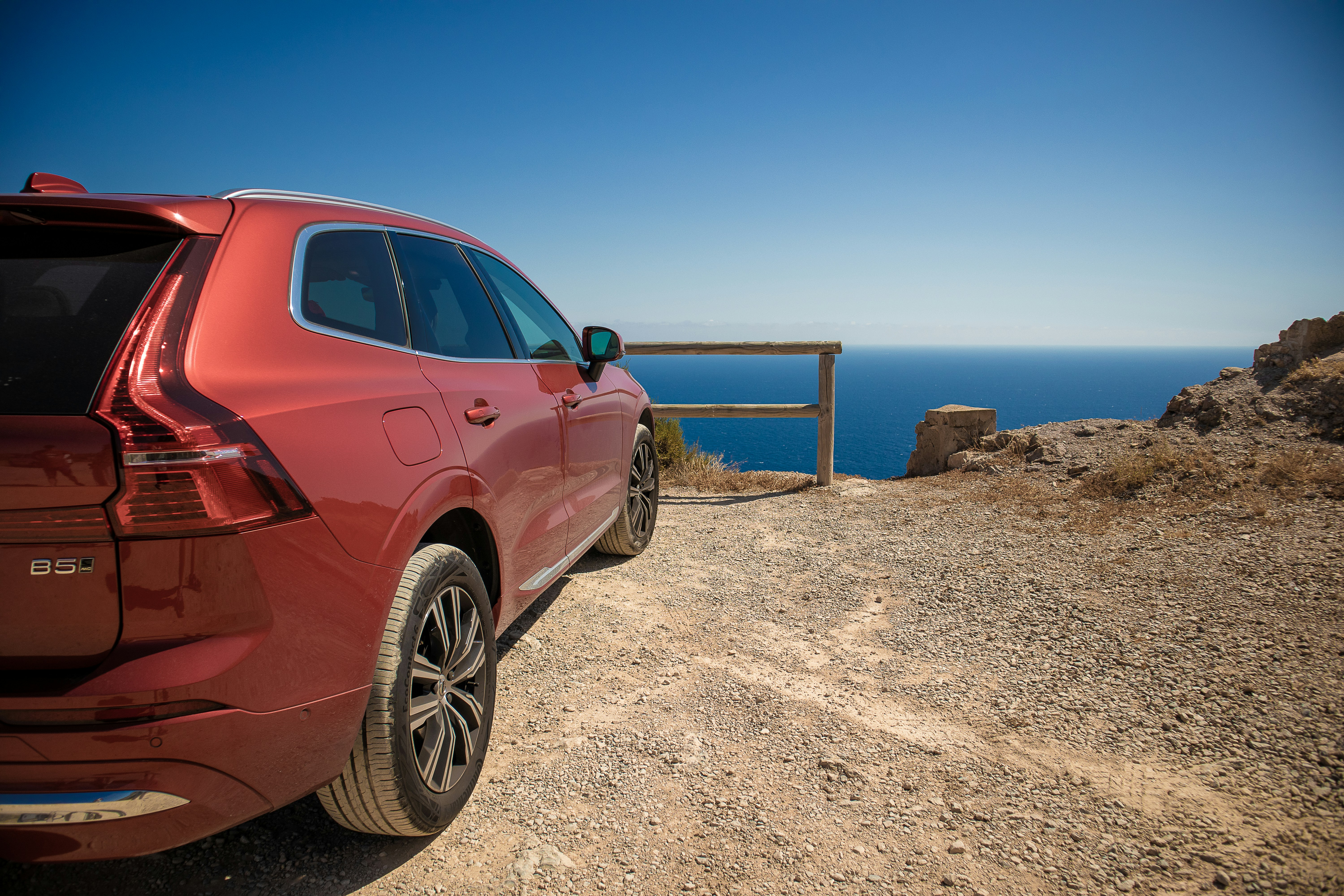 Beach · a red car parked on a rocky beach