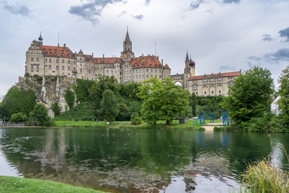 a large building with a moat and trees in front of it