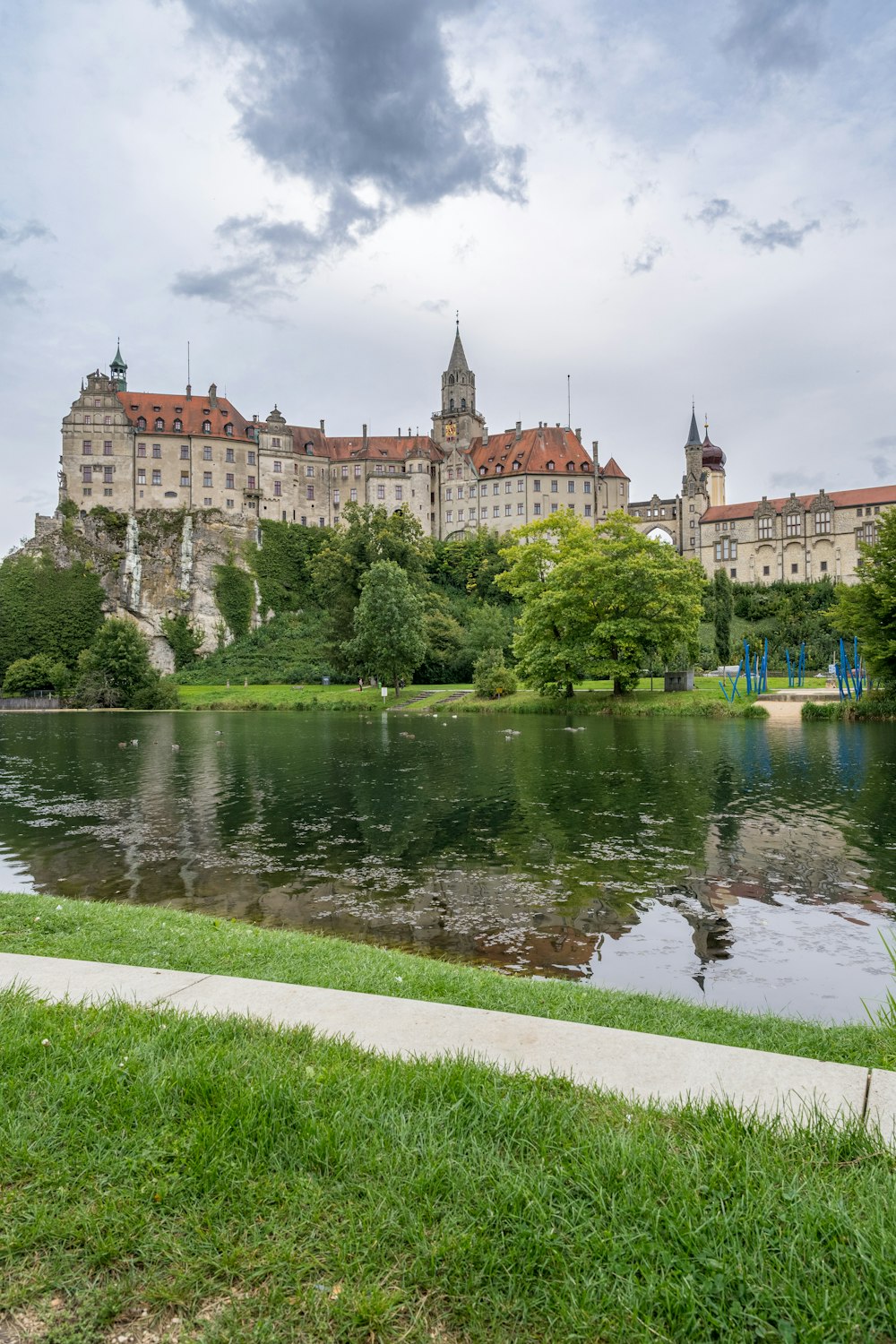 a large building with a moat and trees in front of it