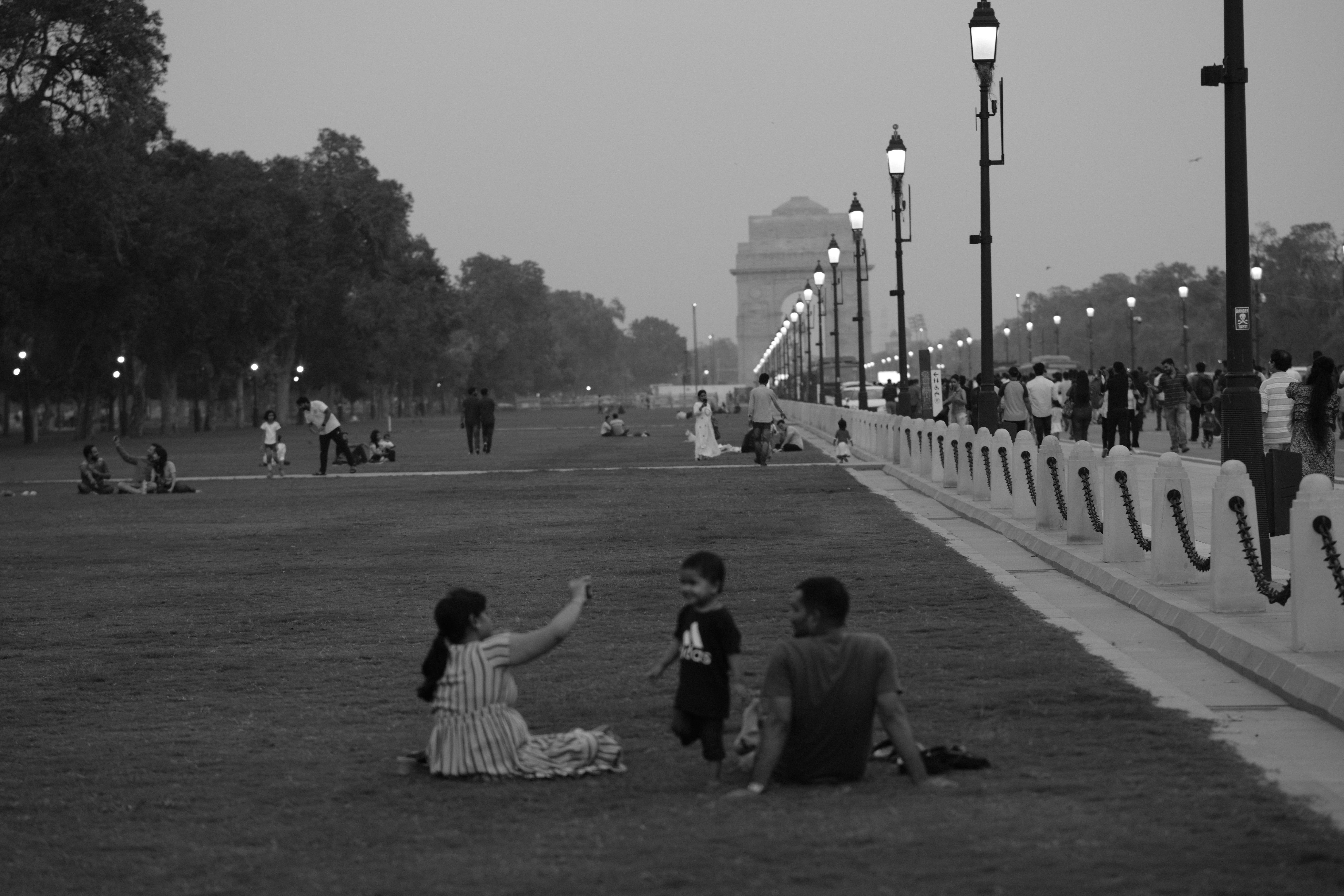 a group of people sitting on a concrete walkway with a crowd watching, 