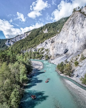 a river with boats on it and mountains in the back