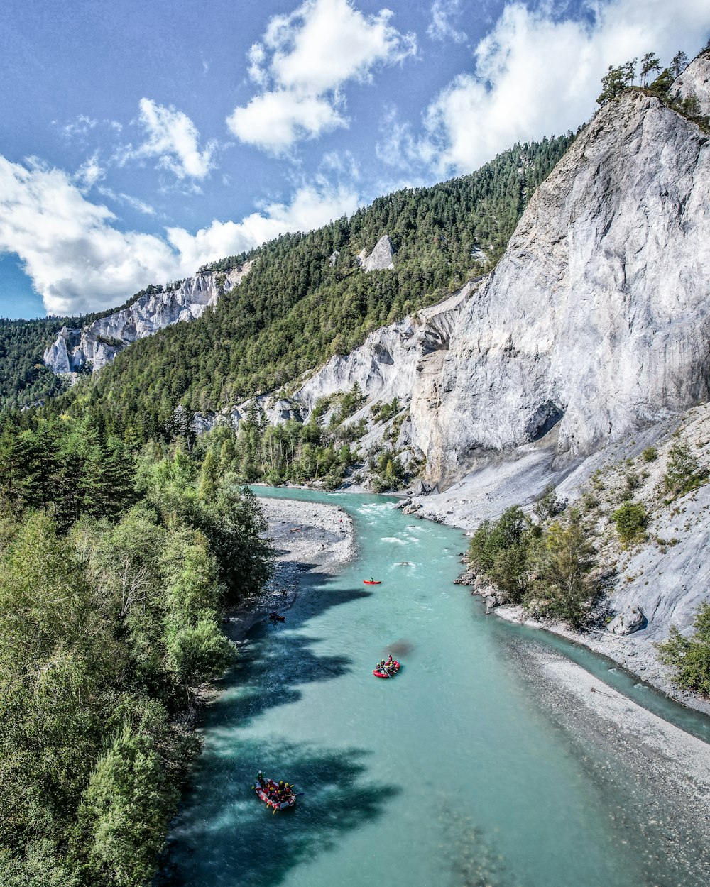 ein Fluss mit Booten darauf und Bergen im Hintergrund