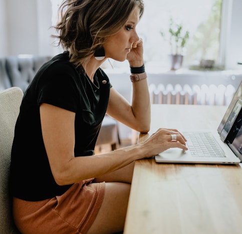 a woman sitting at a table with a laptop