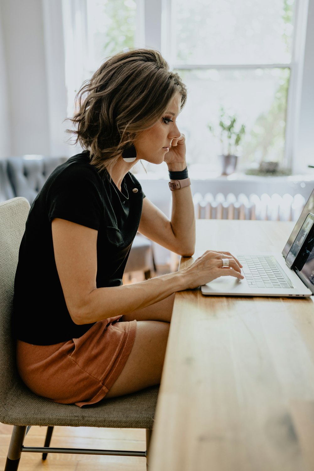 a woman sitting at a table with a laptop