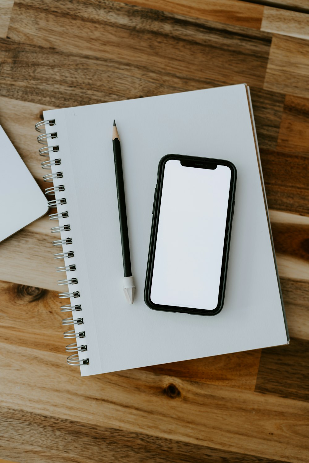 a white rectangular device with a black screen on a wooden surface