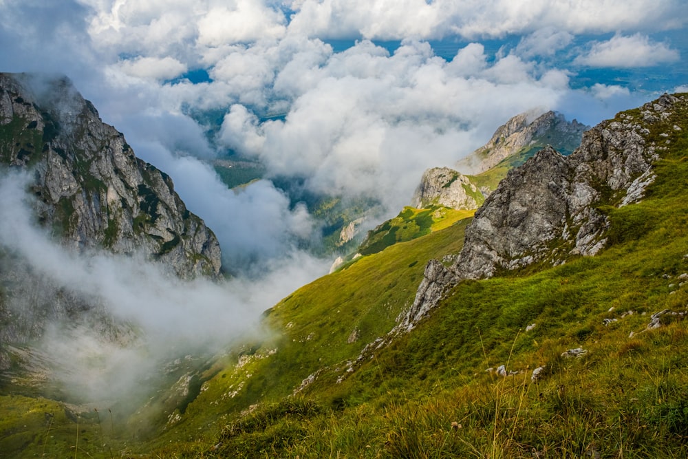 a valley with clouds and mountains