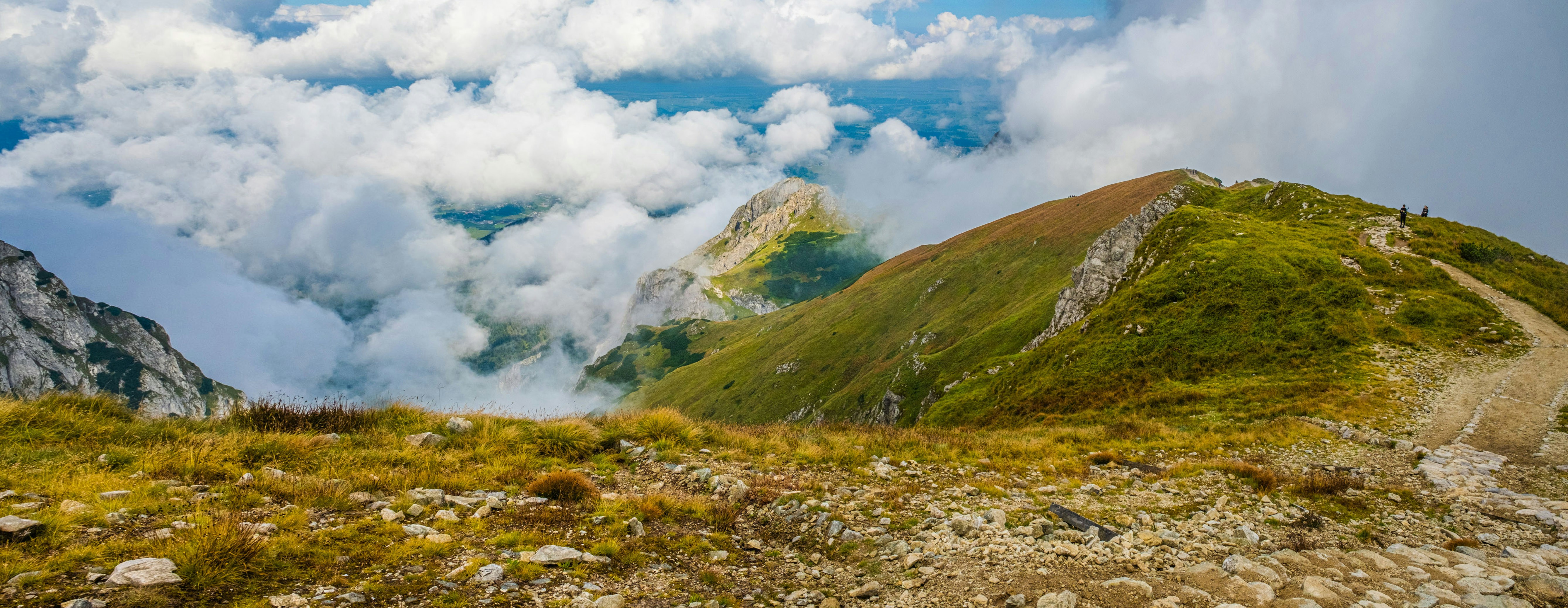Ein grasbewachsener Hügel mit Menschen, die darauf gehen
