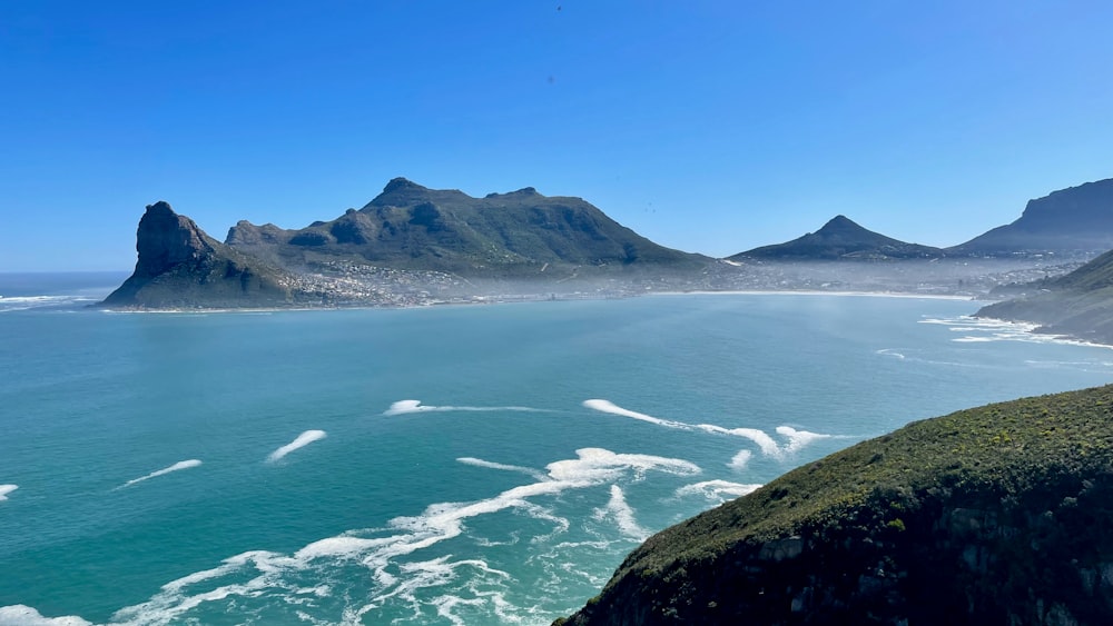 a body of water with hills in the back