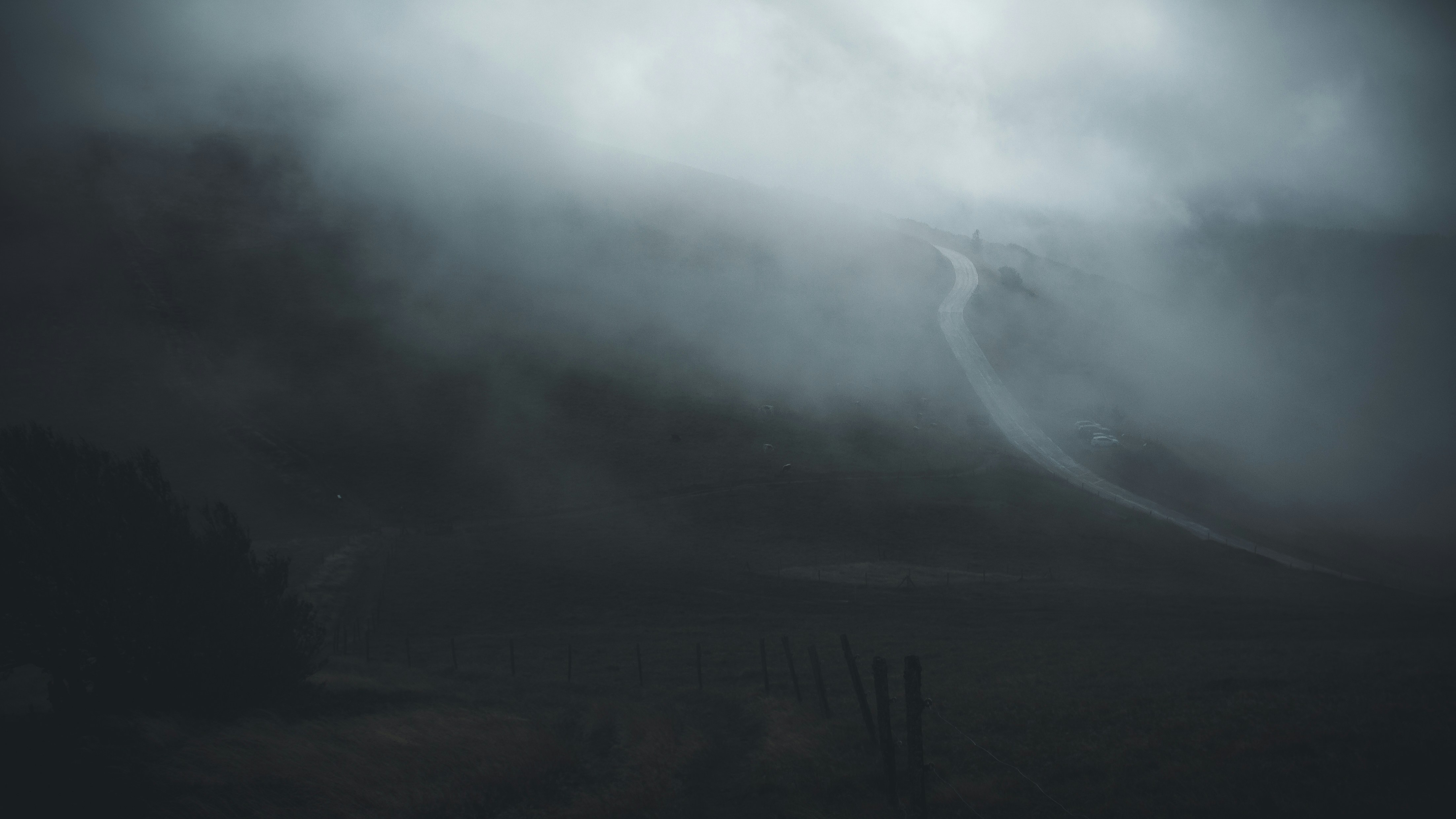a foggy landscape with a fence