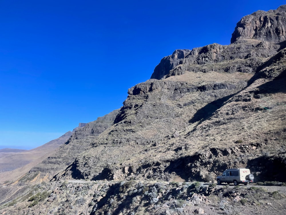 a white van parked on a rocky hill