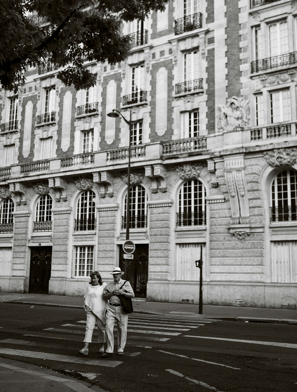 Un couple d’hommes debout devant un immeuble