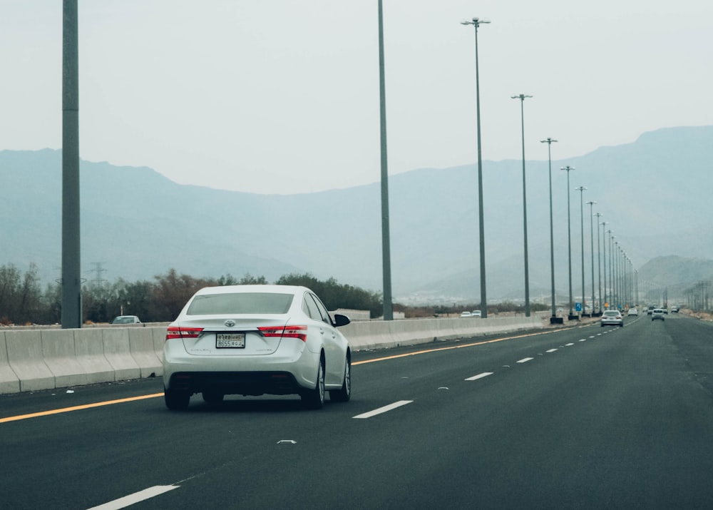 a white car driving on a road