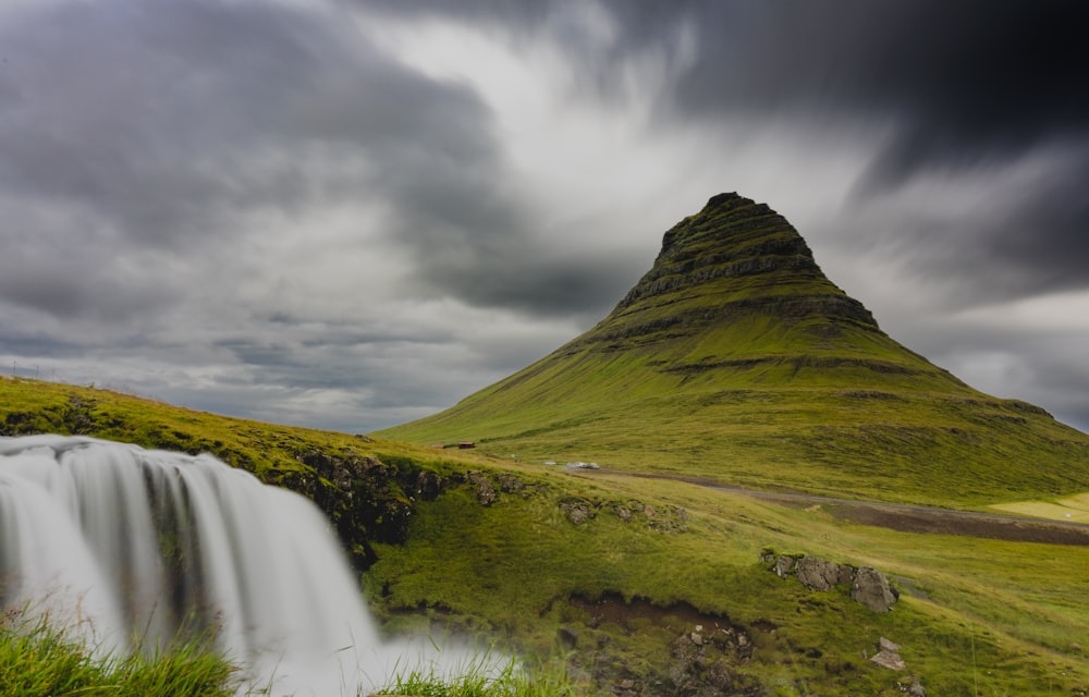 a grassy hill with a waterfall