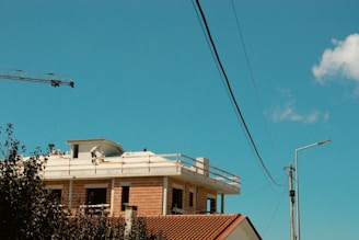 Workers laying electrical cables on a new construction site under clear skies.