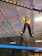 Young woman jumping between obstacles in an indoor parkour training area.