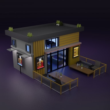 A modern, minimalist building with flat roof design, featuring potted plants on top. The structure includes exterior advertising signs that display images of food, likely indicating a restaurant. The building is flanked by outdoor seating areas with tables, chairs, and small potted plants, all enclosed by low fencing. The overall design suggests a contemporary, stylish establishment.