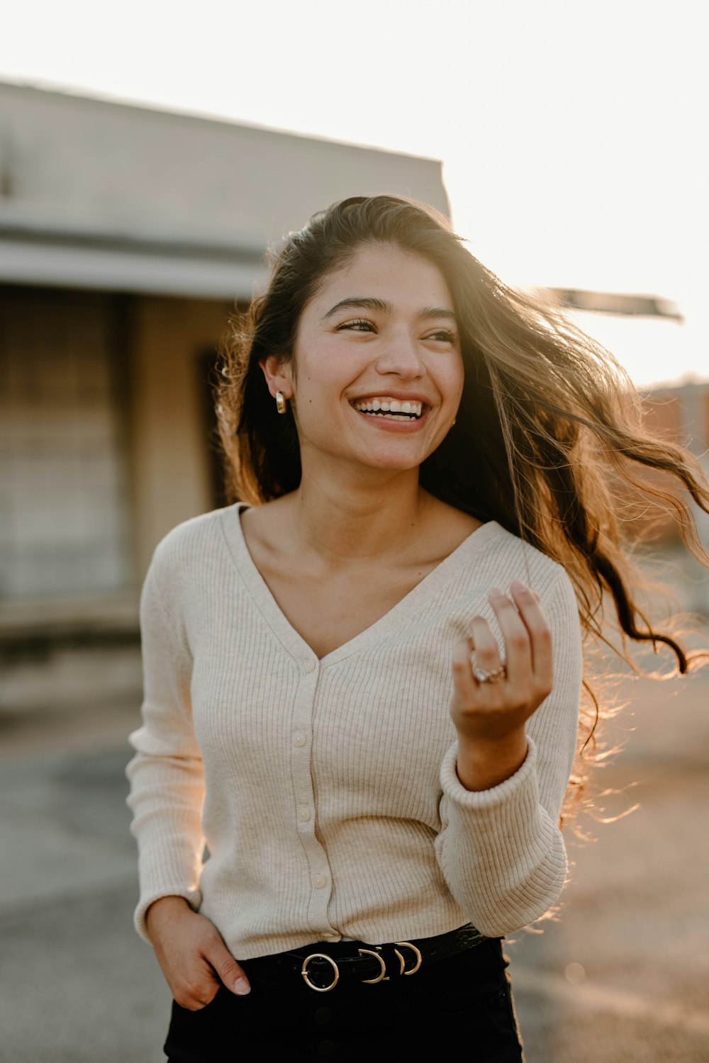 a woman smiling and holding a small object