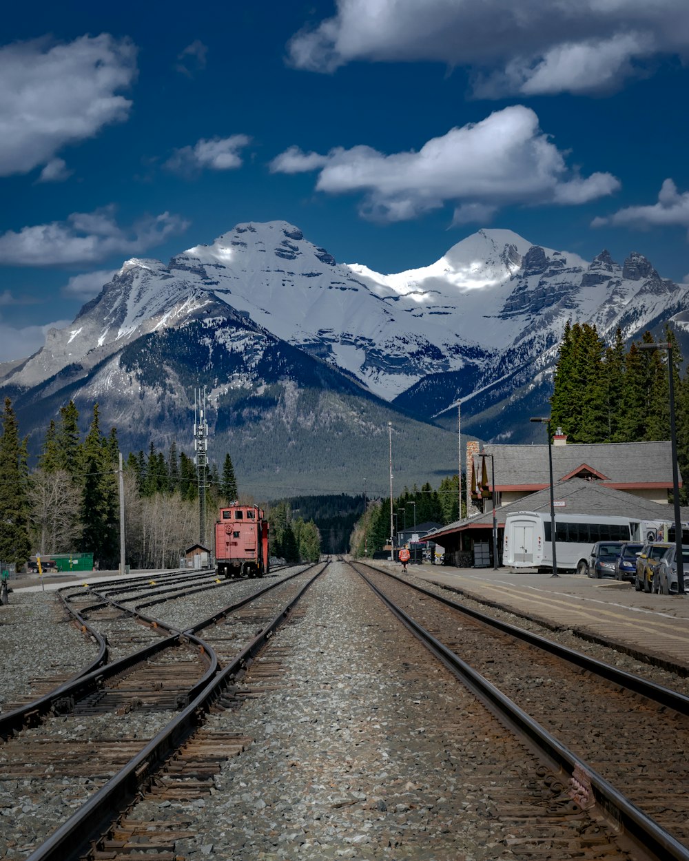 train tracks with a snowy mountain in the background