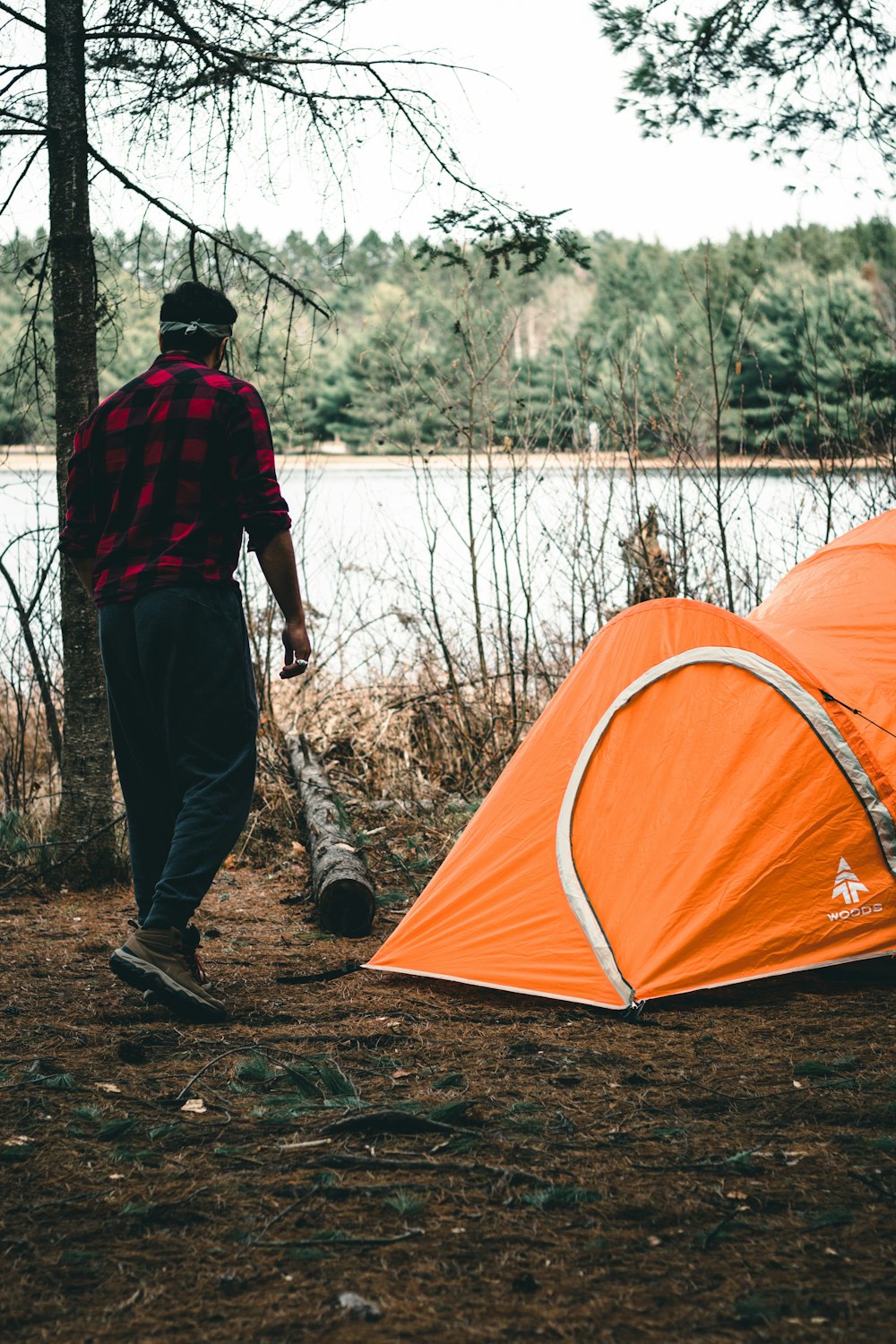 a man standing next to a tent