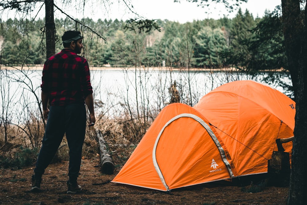 a man standing next to a tent