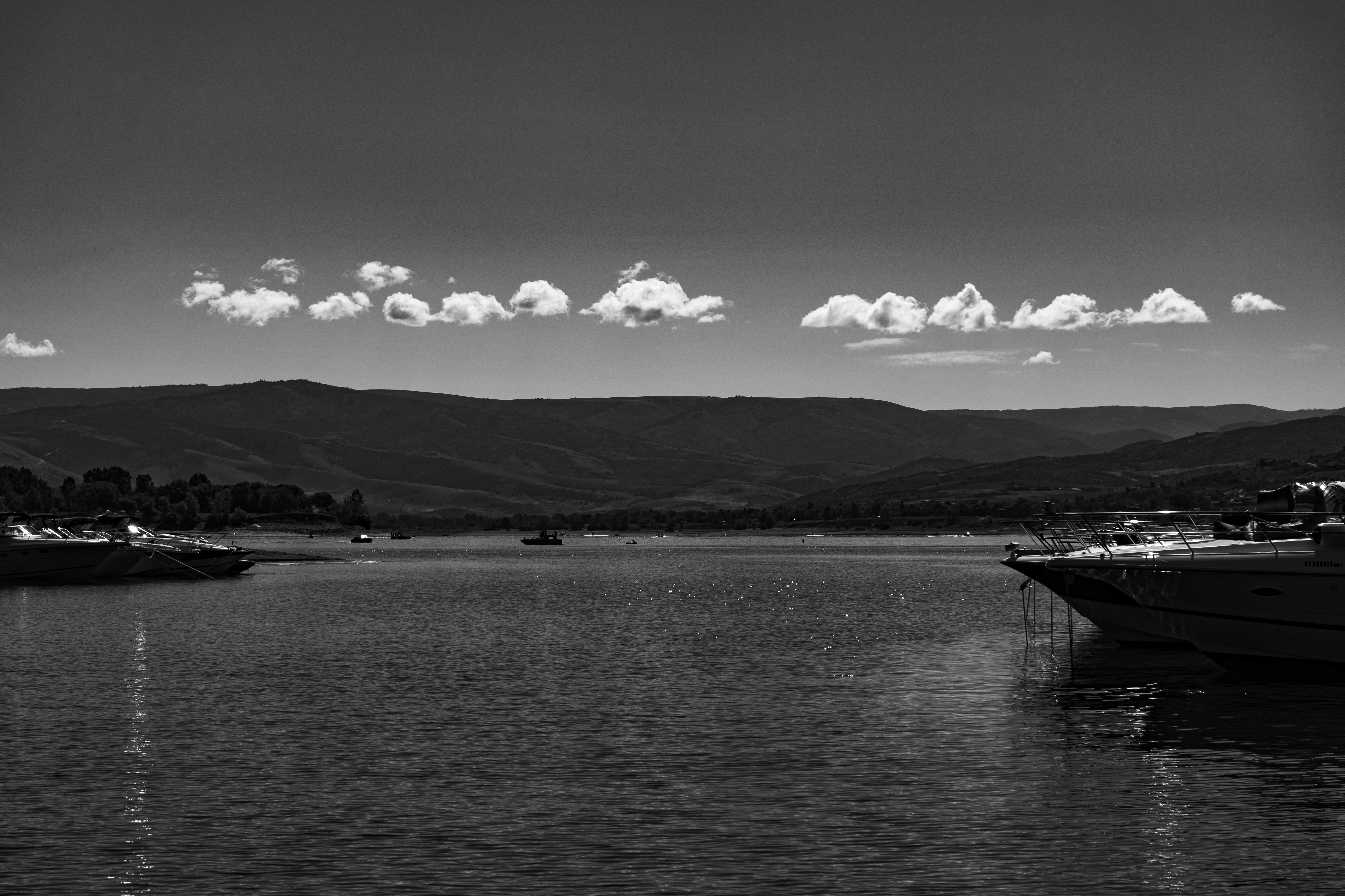 a body of water with boats and mountains in the background