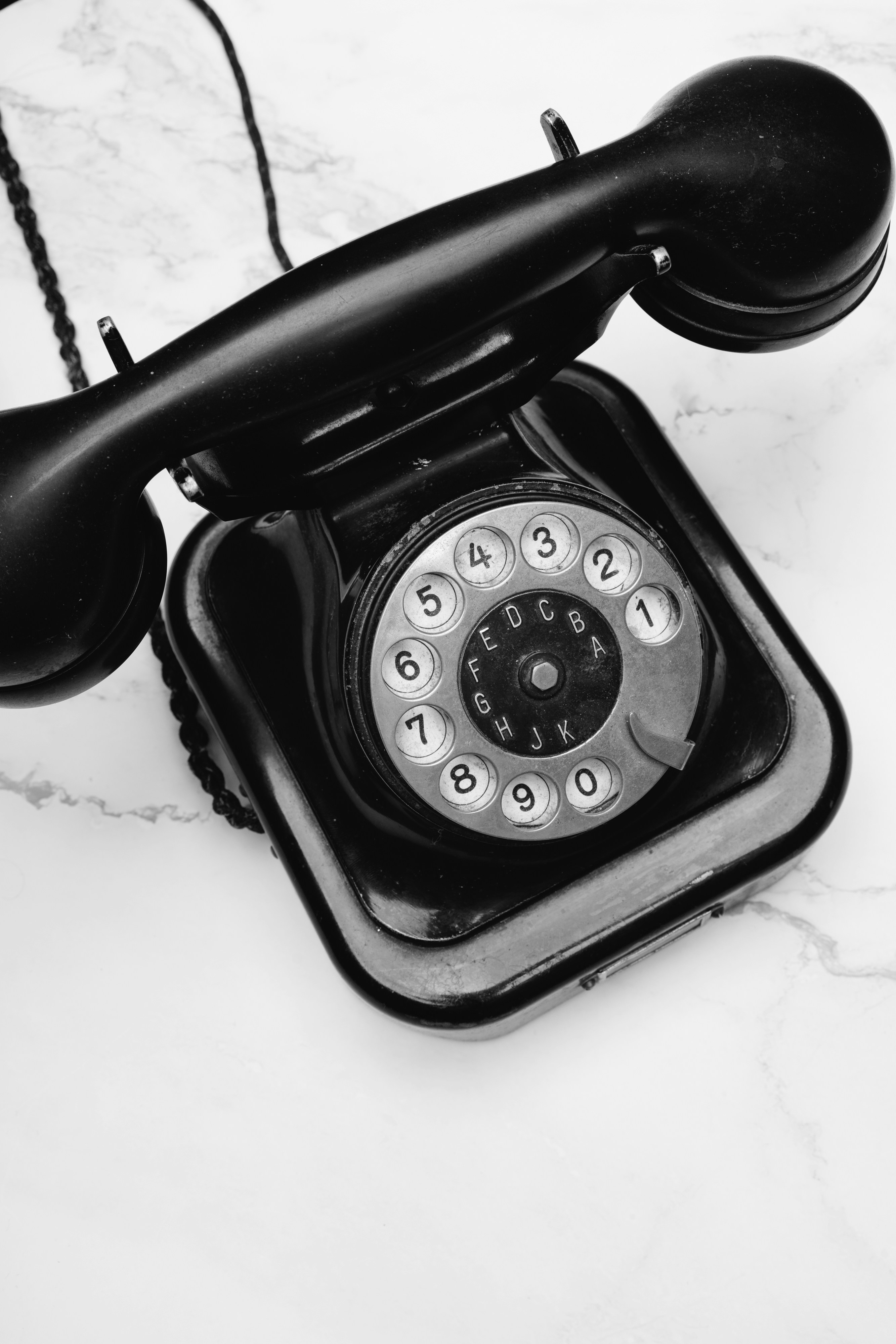 a black telephone with a cord