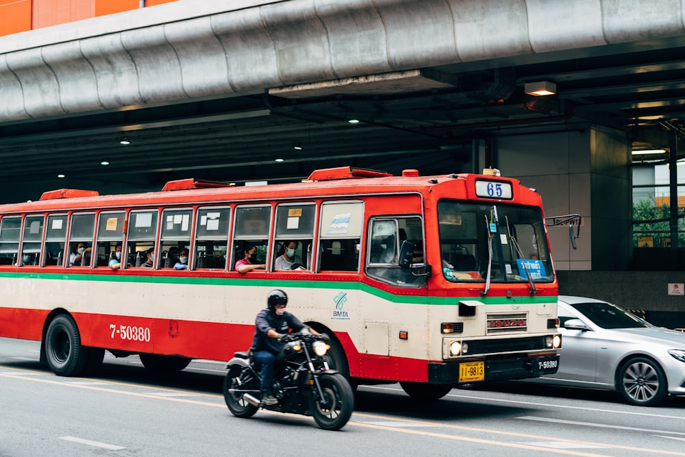 a person riding a motorcycle next to a bus