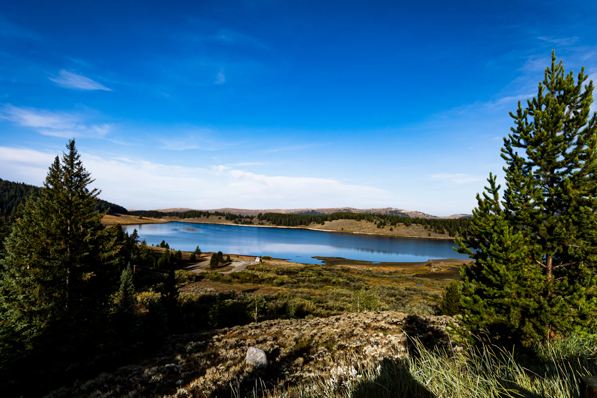 A blue lake ringed by pines and meadows in the Bighorn National Forest