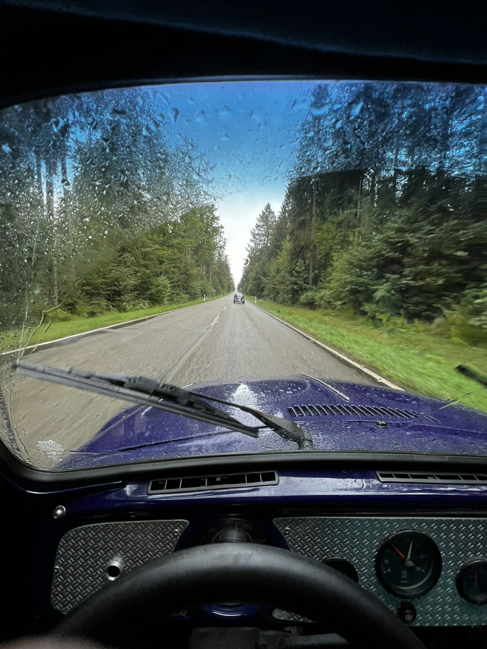 a view of a road through a windshield of a car