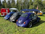 A line-up of restored Skoda models from the 80s at a weekend club show in a green field.